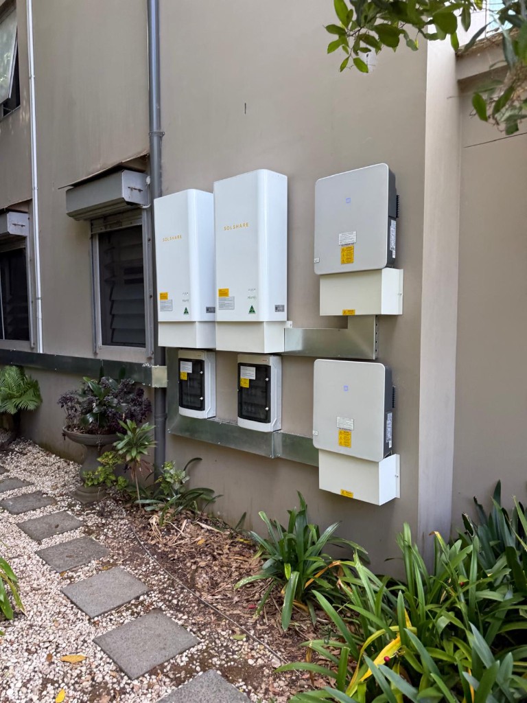 SolShare units and switchboards on exterior stucco wall