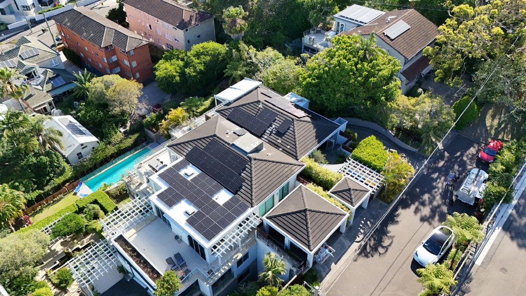 Aerial view of modern home with extensive rooftop solar panels